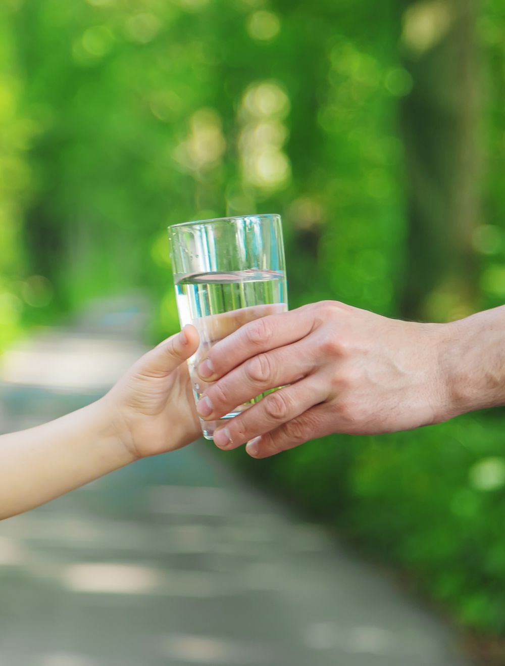 Main tendant un verre d’eau claire symbolisant un puits artésien à Pontiac.